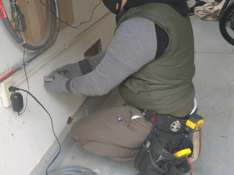 Electrician performing outlet wiring in a Summerside garage